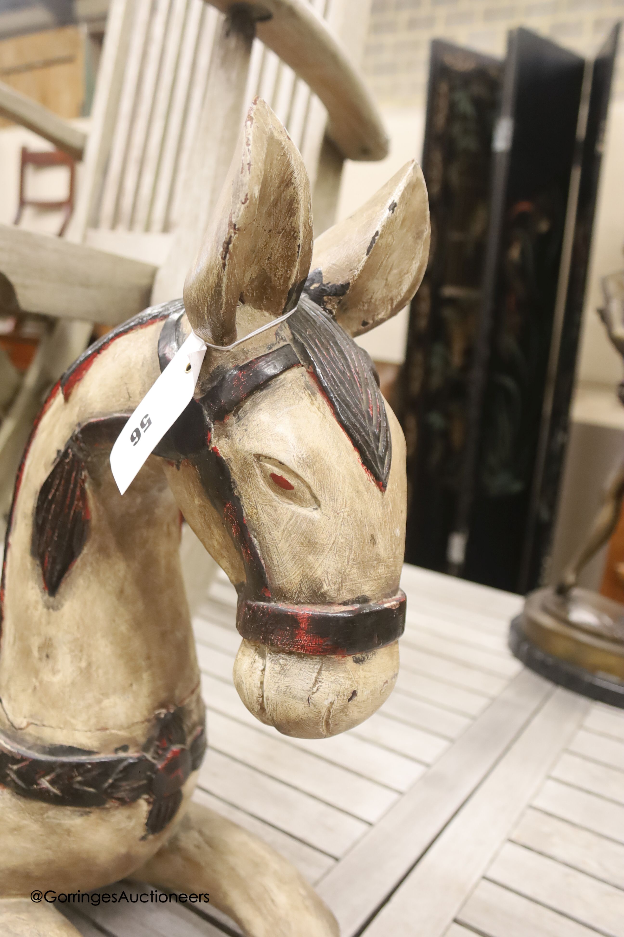 An Indonesian carved hardwood model of a recumbent horse, length 82cm, height 54cm